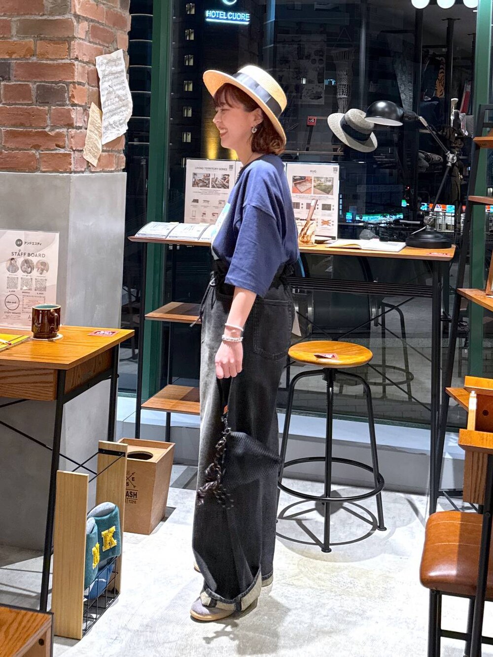 グレー系のデニムパンツ、ブルー系のTシャツ/カットソー、ベージュ系のハットを着用したレディースの夏コーディネートの2枚目の写真