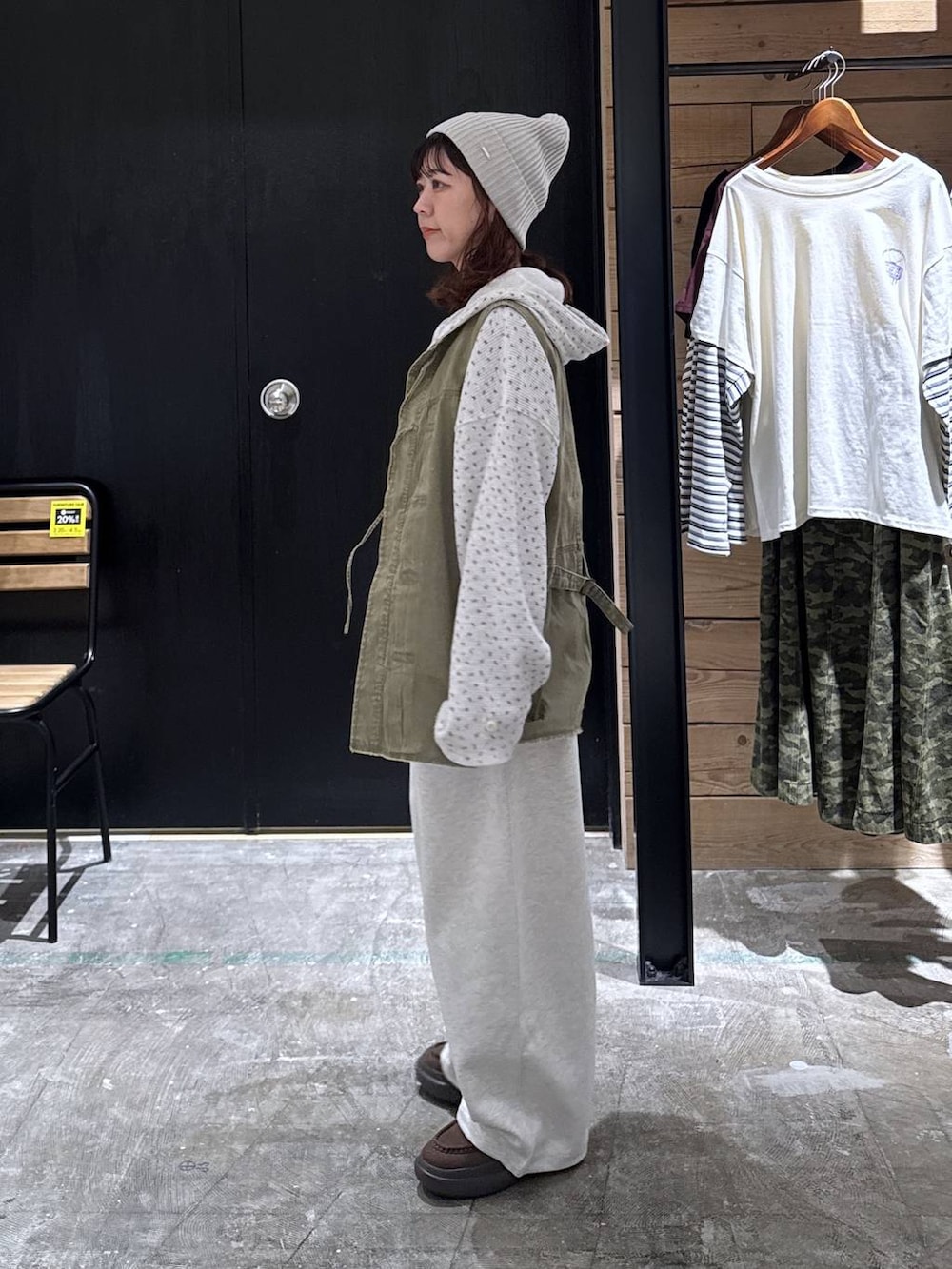 グリーン系のベスト、ベージュ系のパーカー、ブラウン系のローファーを着用したレディースの冬コーディネートの3枚目の写真