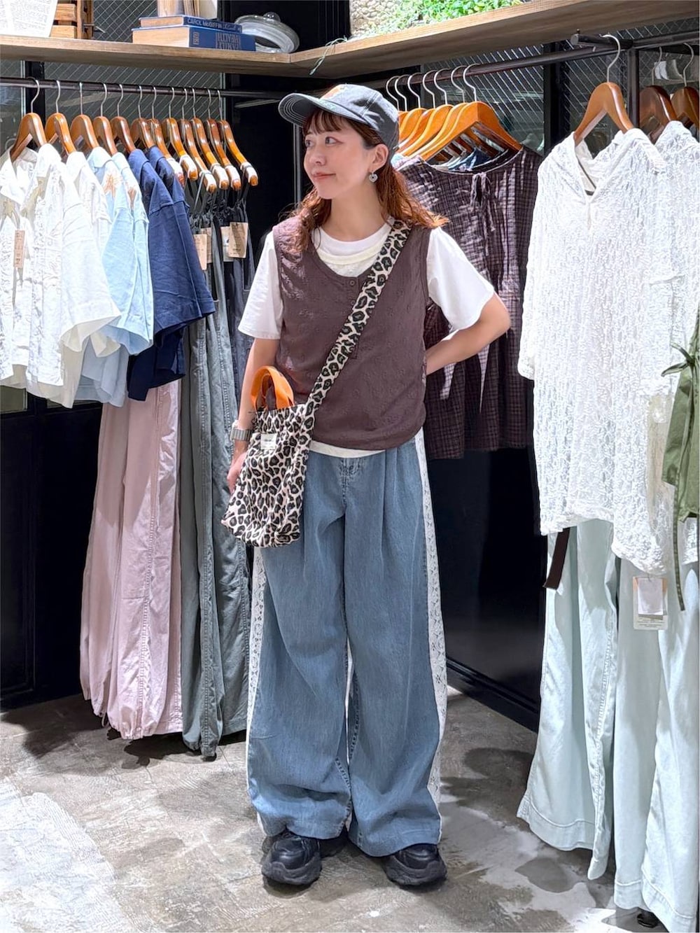 その他のトートバッグ、ブラウン系のタンクトップ、ブルー系のデニムパンツを着用したレディースの夏コーディネートの5枚目の写真
