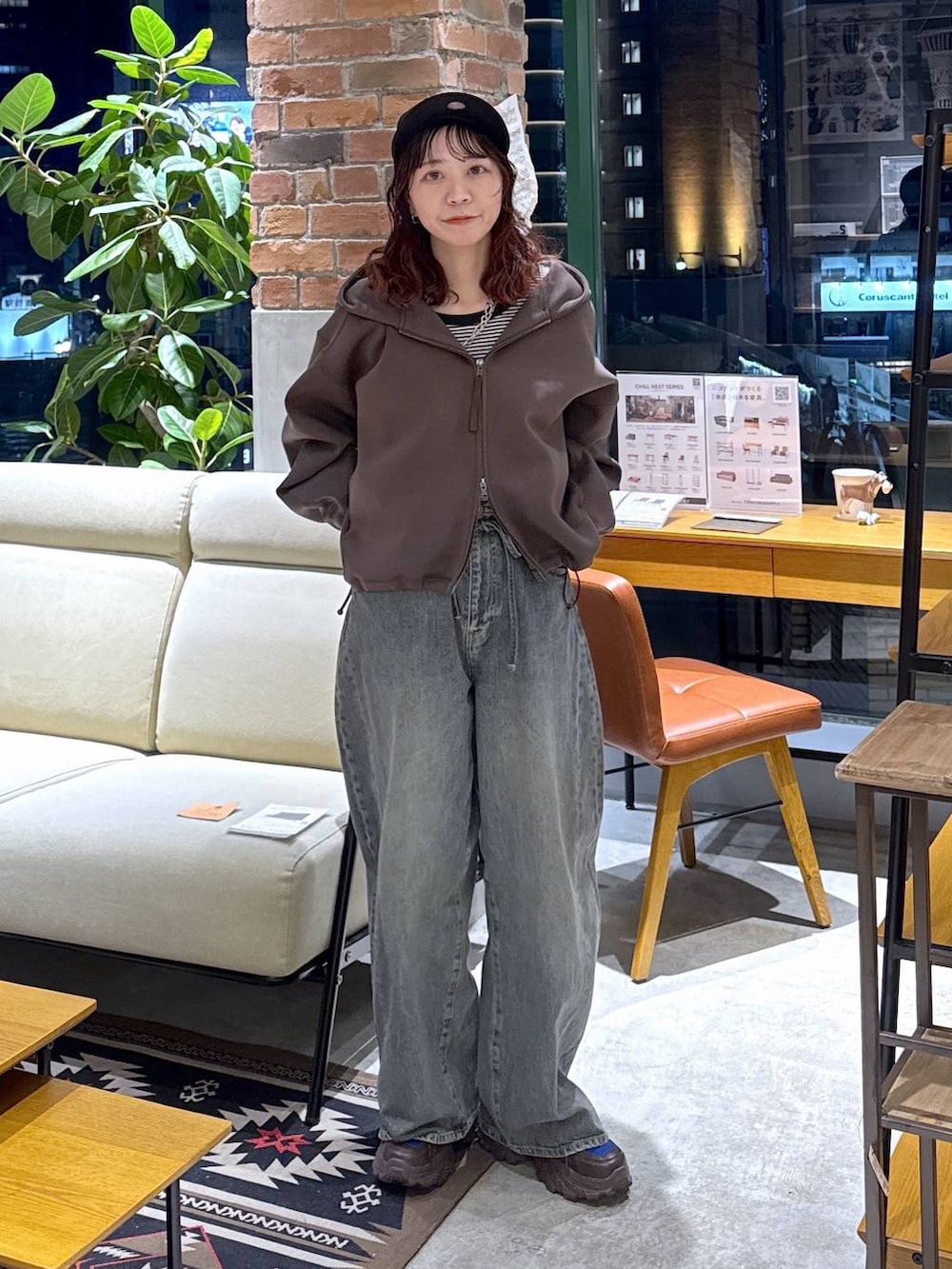 ブラウン系のスニーカー、ブルー系のデニムパンツ、ブラウン系のパーカーを着用したレディースの冬コーディネートの8枚目の写真