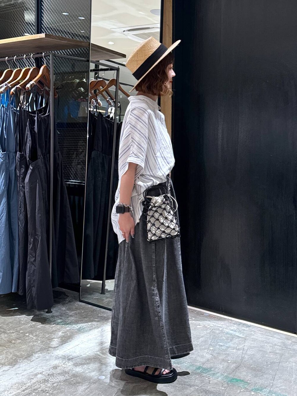 ブラック系のショルダーバッグ、ブラック系のサンダル、ベージュ系のシャツ/ブラウスを着用したレディースの夏コーディネートの3枚目の写真