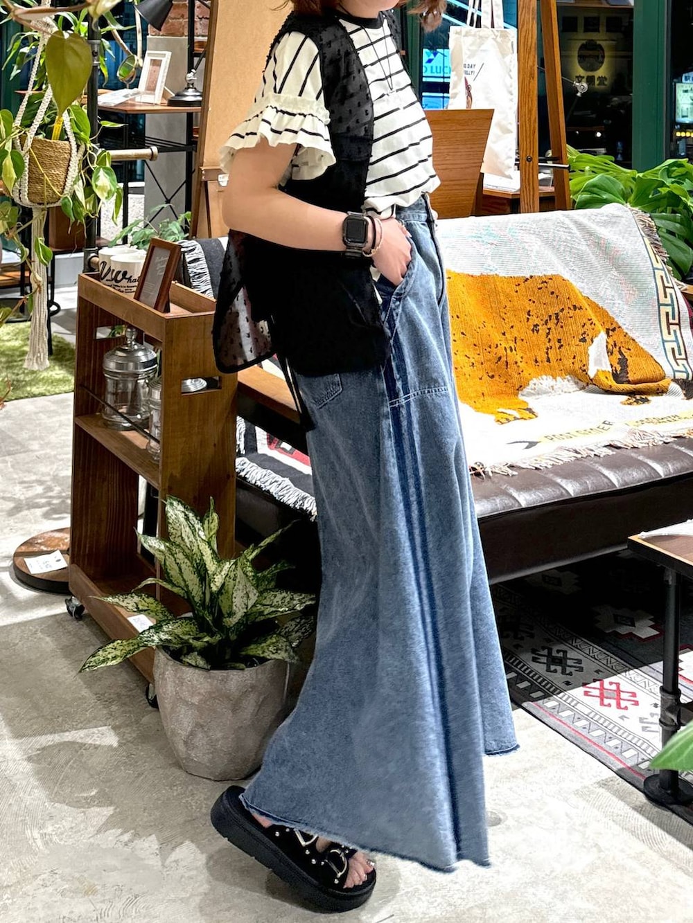 ブラック系のサンダル、ブラック系のベスト、ブルー系のスカートを着用したレディースの夏コーディネートの8枚目の写真