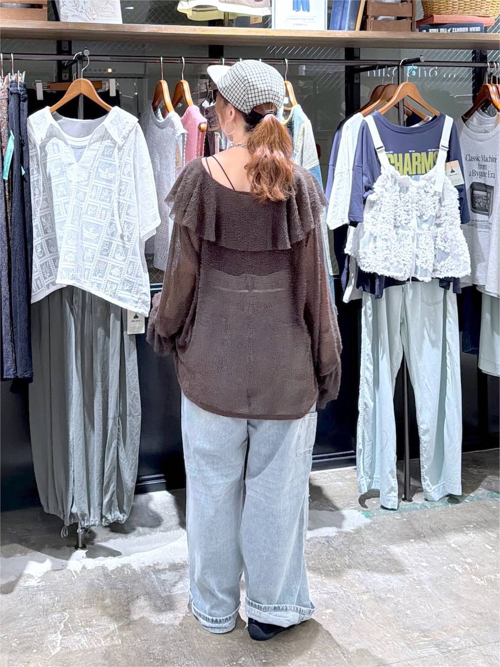 ブラウン系のカーディガン/ボレロ、ブルー系のデニムパンツ、ブラック系のキャップを着用したレディースの秋コーディネートの4枚目の写真