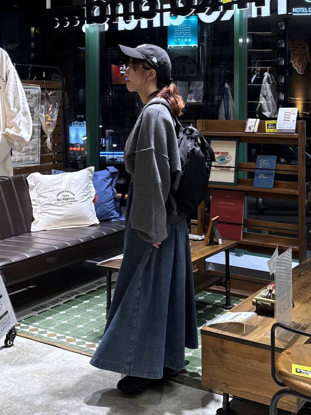 ブルー系のスカート、グレー系のTシャツ/カットソー、ブラック系のバックパック/リュックを着用したレディースの春コーディネートの3枚目の写真