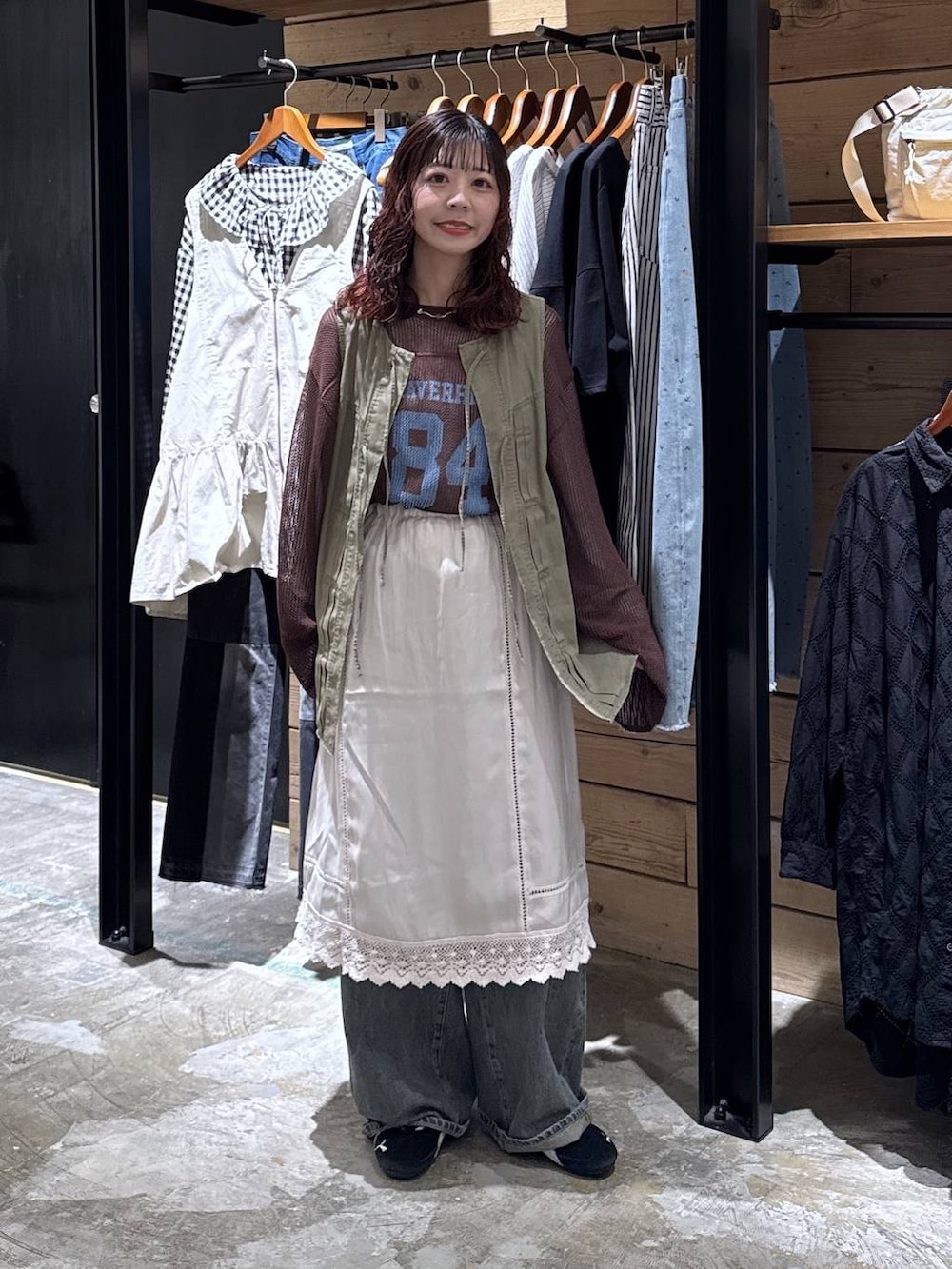 グリーン系のベスト、ブルー系のデニムパンツ、ベージュ系のTシャツ/カットソーを着用したレディースの春コーディネートの7枚目の写真