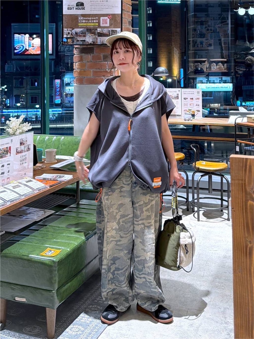 グレー系のベスト、グリーン系のデニムパンツ、グリーン系のショルダーバッグを着用したレディースの夏コーディネートの7枚目の写真