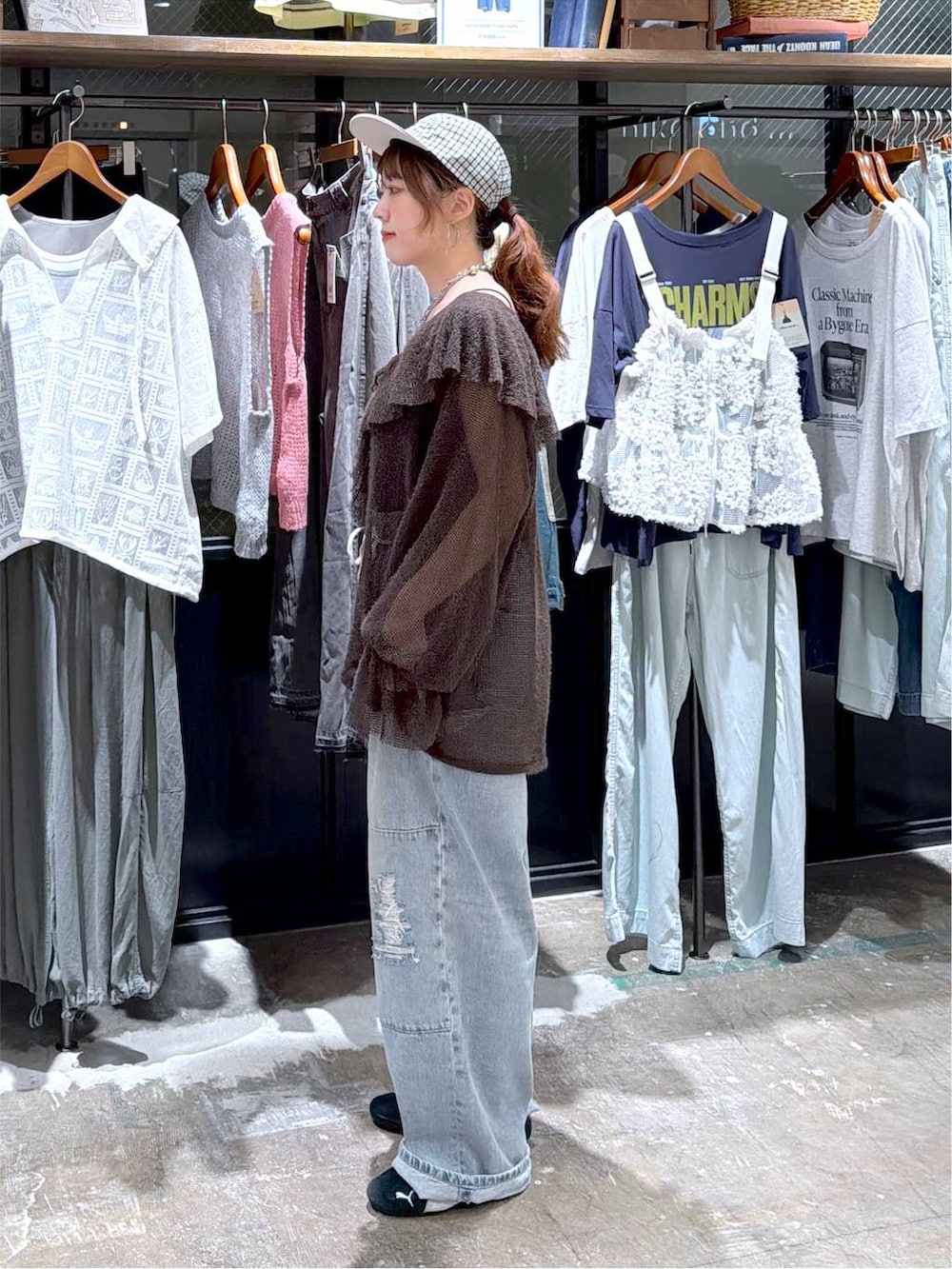 ブラウン系のカーディガン/ボレロ、ブルー系のデニムパンツ、ブラック系のキャップを着用したレディースの秋コーディネートの3枚目の写真