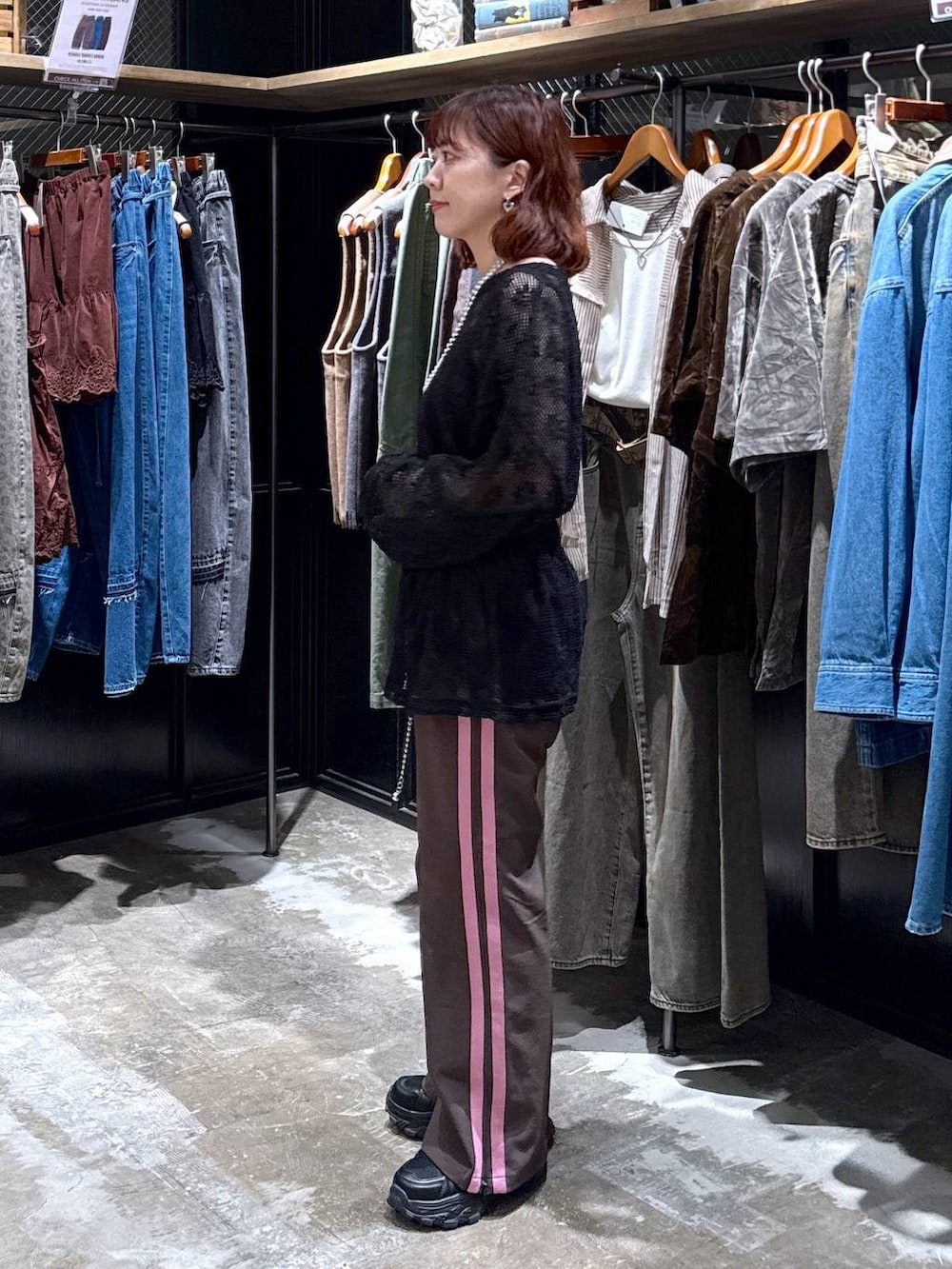 ブラウン系のその他パンツ、ブラック系のTシャツ/カットソー、ブラック系のスニーカーを着用したレディースの秋コーディネートの2枚目の写真