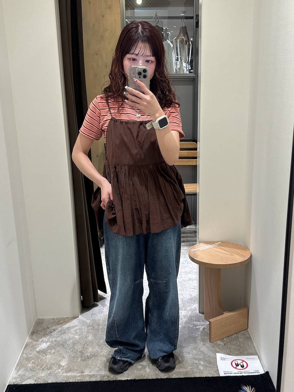 ブルー系のデニムパンツ、オレンジ系のTシャツ/カットソー、ブラウン系のキャミソールを着用したレディースの夏コーディネートの2枚目の写真