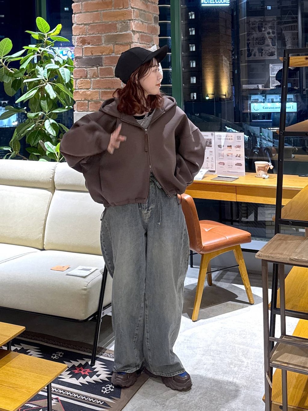 ブラウン系のスニーカー、ブルー系のデニムパンツ、ブラウン系のパーカーを着用したレディースの冬コーディネートの7枚目の写真