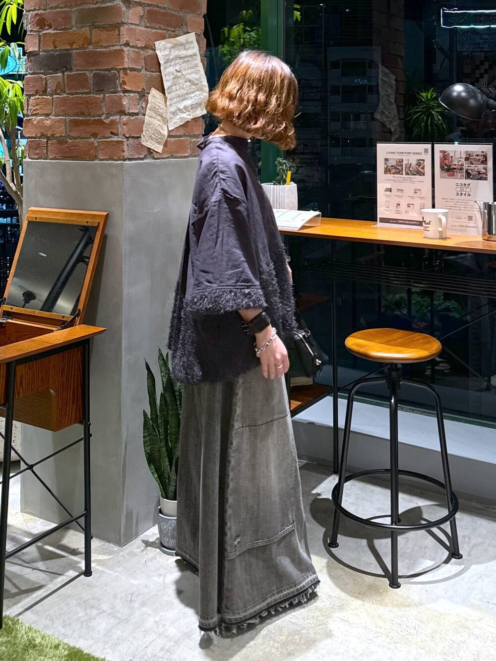 ブラック系のバレエシューズ、ブラック系のショルダーバッグ、ブラウン系のデニムパンツを着用したレディースの秋コーディネートの3枚目の写真