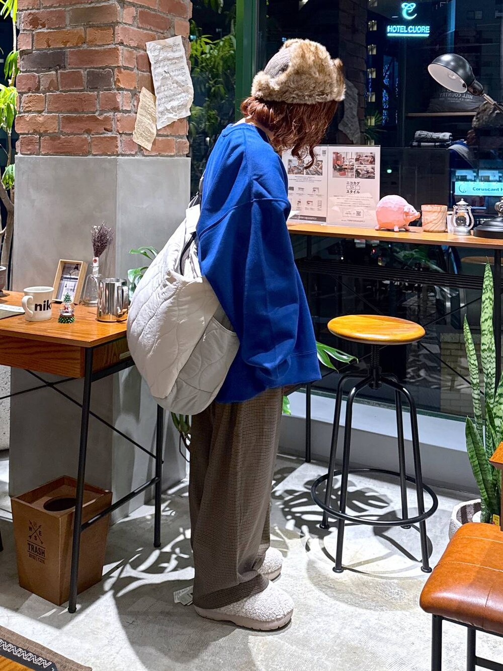 ブラウン系のその他パンツ、ブルー系のスウェット、ホワイト系のショルダーバッグを着用したレディースの冬コーディネートの4枚目の写真