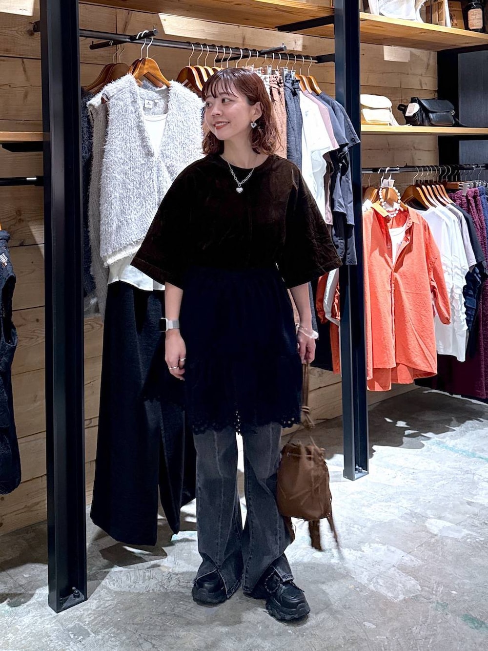 ブラウン系のシャツ/ブラウス、グレー系のデニムパンツ、ブラック系のスカートを着用したレディースの夏コーディネートの2枚目の写真