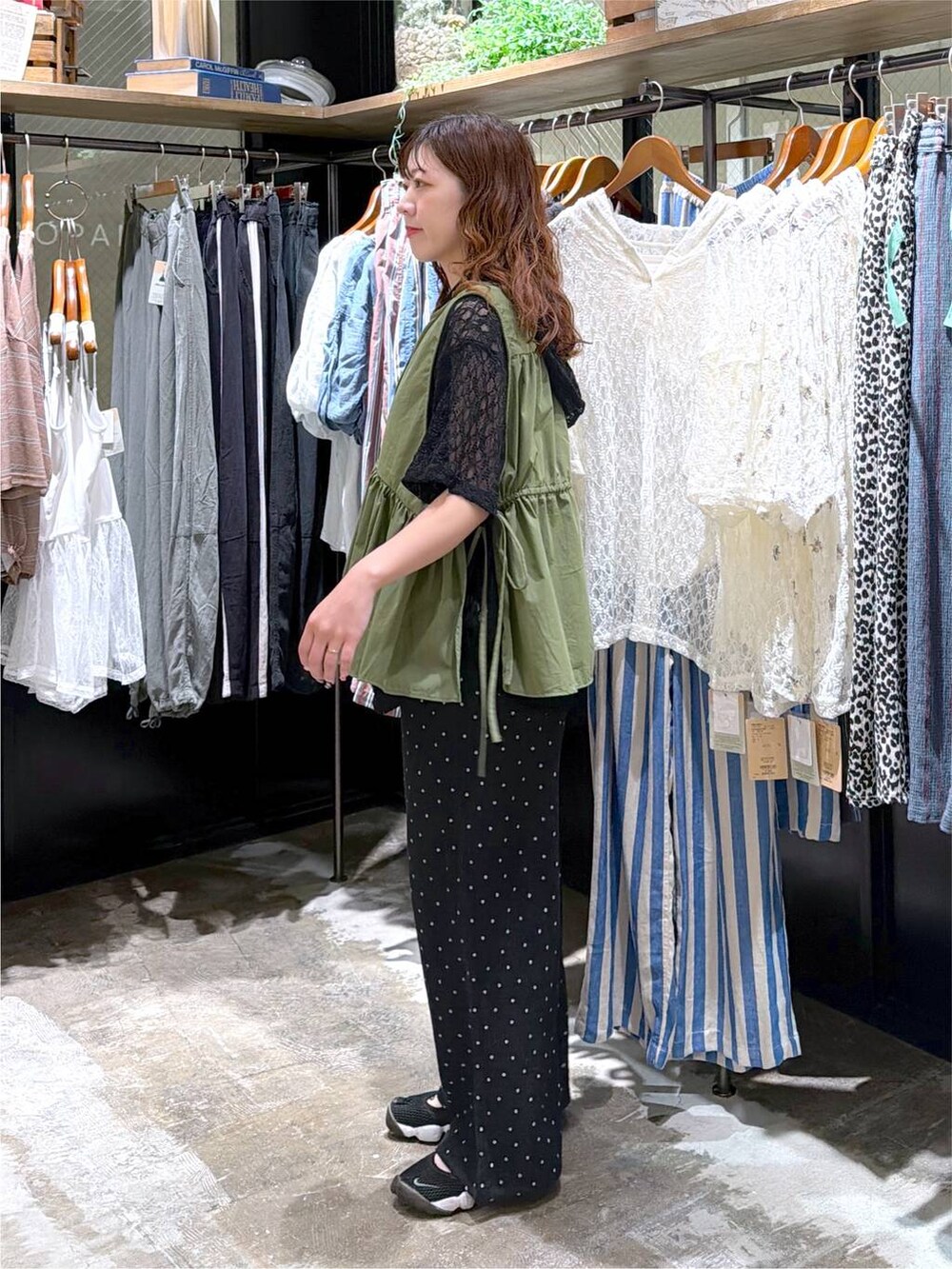グレー系のその他パンツ、グリーン系のベストを着用したレディースの夏コーディネートの4枚目の写真