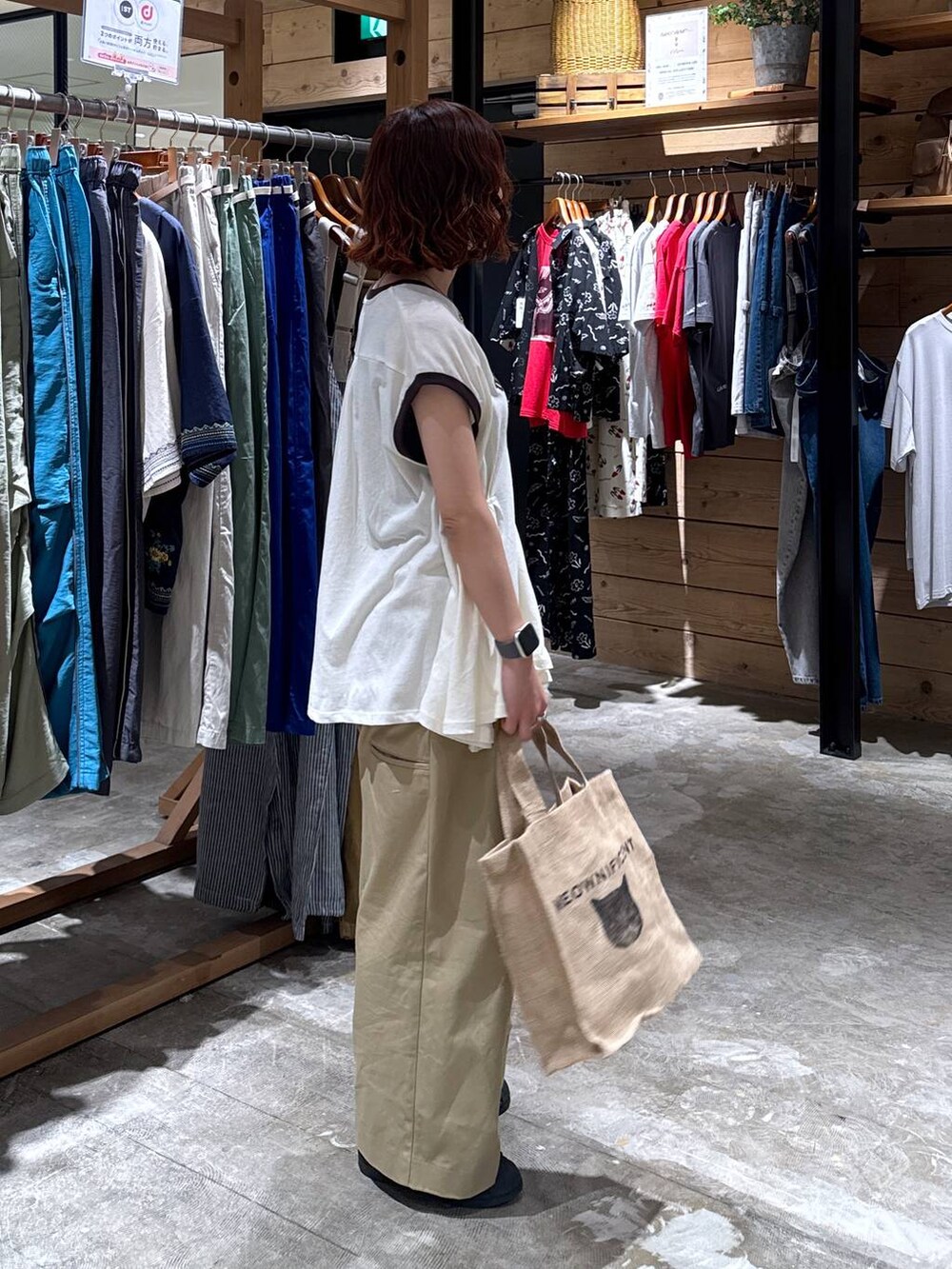 ベージュ系のチノパンツ、ホワイト系のTシャツ/カットソー、ブラック系のトートバッグを着用したレディースの夏コーディネートの4枚目の写真