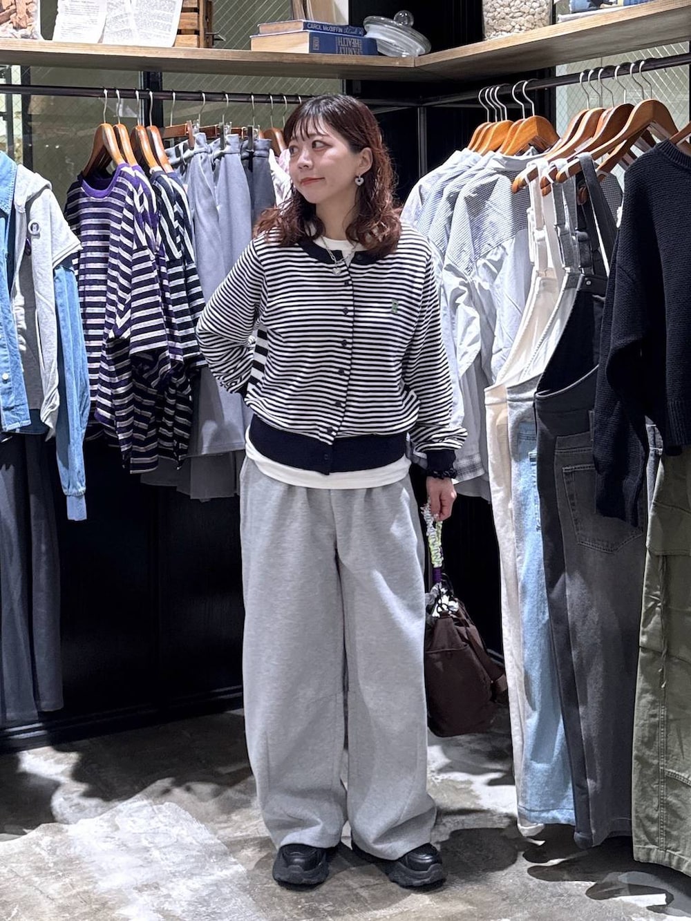 ブラック系のスニーカー、グレー系のスウェットパンツ、その他のショルダーバッグを着用したレディースの冬コーディネートの2枚目の写真