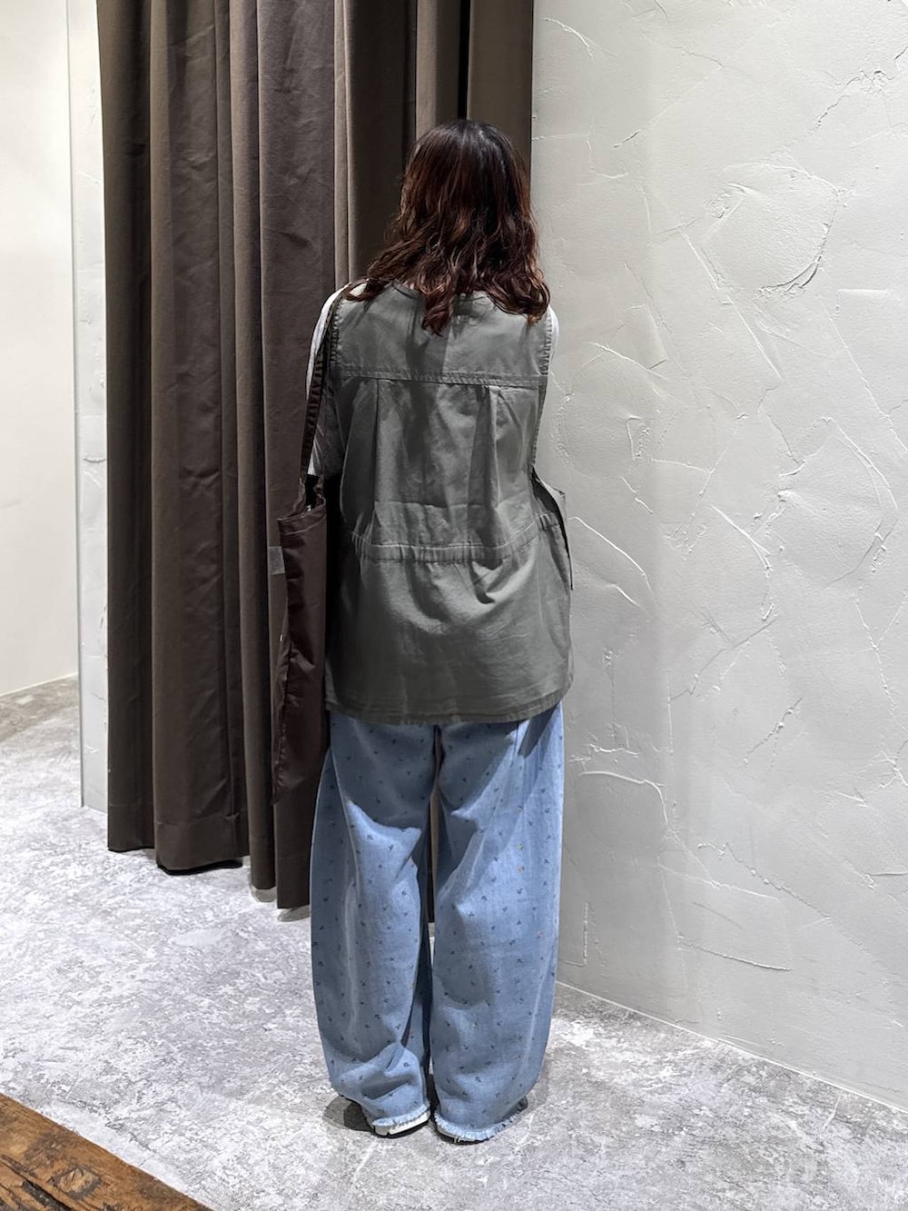 シルバー系のスニーカー、ブラウン系のトートバッグ、ブルー系のデニムパンツを着用したレディースの冬コーディネートの5枚目の写真