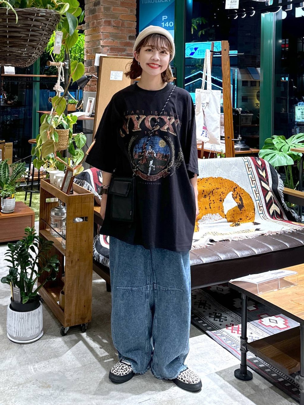 ブラック系のショルダーバッグ、ブルー系のデニムパンツ、ブラック系のTシャツ/カットソーを着用したレディースの夏コーディネートの7枚目の写真