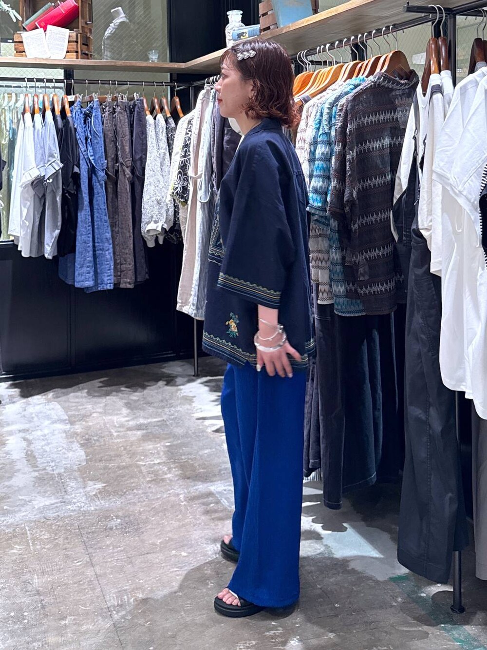 グレー系のタンクトップ、ブラック系のサンダル、ブルー系のその他パンツを着用したレディースの夏コーディネートの2枚目の写真