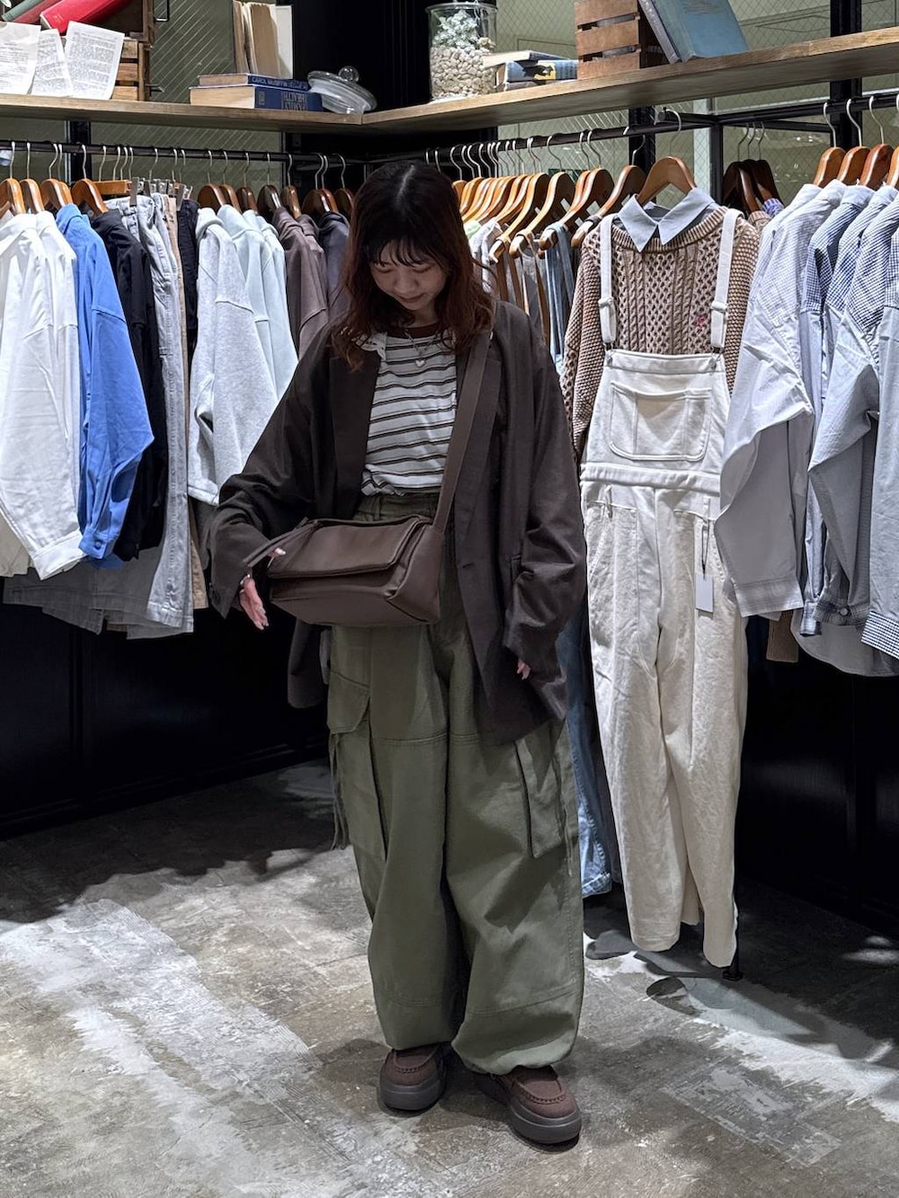 ブラウン系のショルダーバッグ、グリーン系のカーゴパンツ、ブルー系のTシャツ/カットソーを着用したレディースの冬コーディネートの6枚目の写真