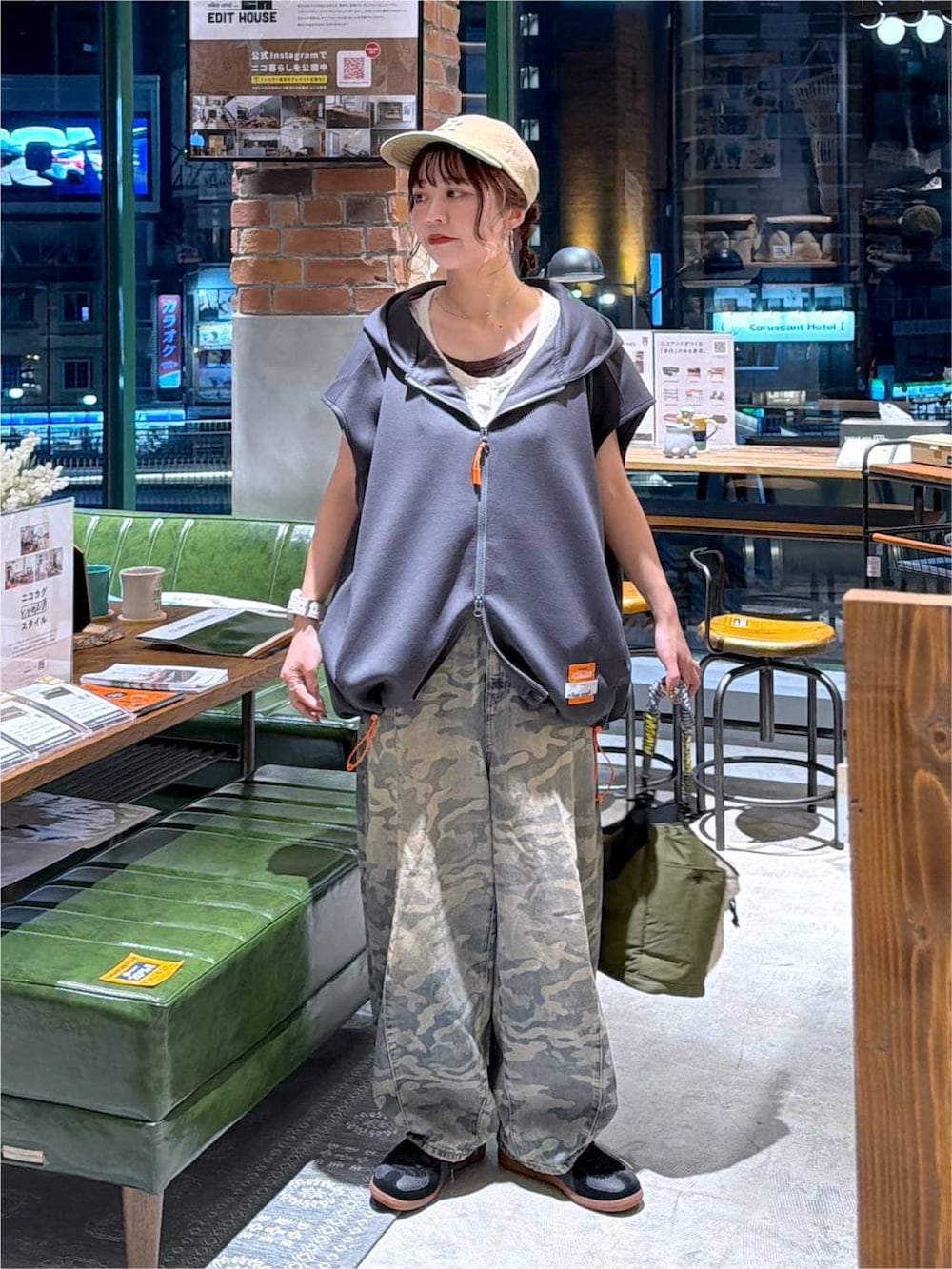 グレー系のベスト、グリーン系のデニムパンツ、グリーン系のショルダーバッグを着用したレディースの夏コーディネートの9枚目の写真