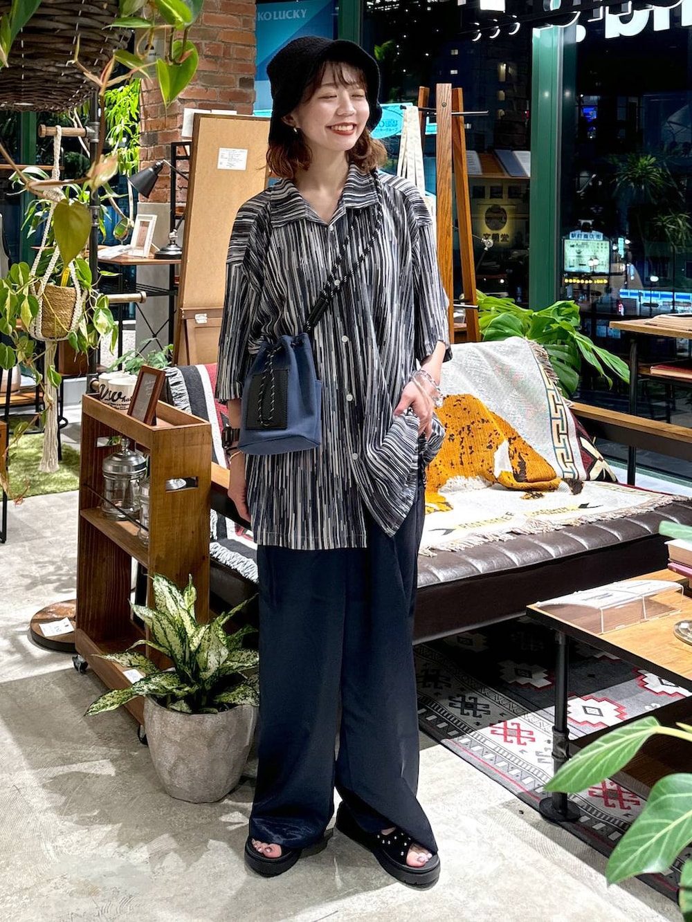 ブラック系のサンダル、ブルー系のショルダーバッグ、ブルー系のシャツ/ブラウスを着用したレディースの夏コーディネートの4枚目の写真