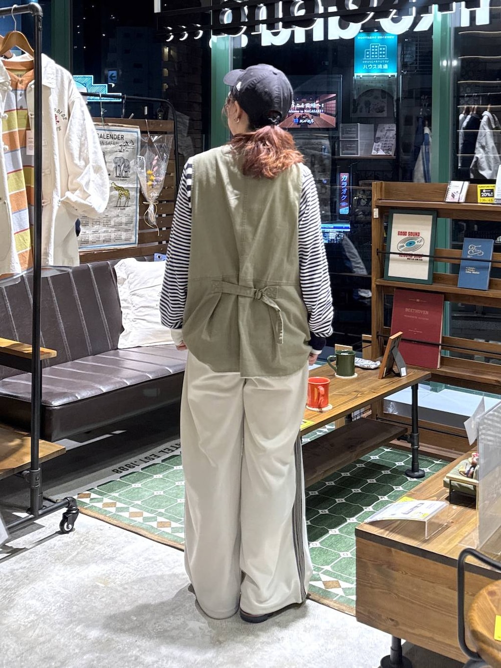 グリーン系のベスト、ベージュ系のその他パンツ、ブルー系のカーディガン/ボレロを着用したレディースの冬コーディネートの3枚目の写真