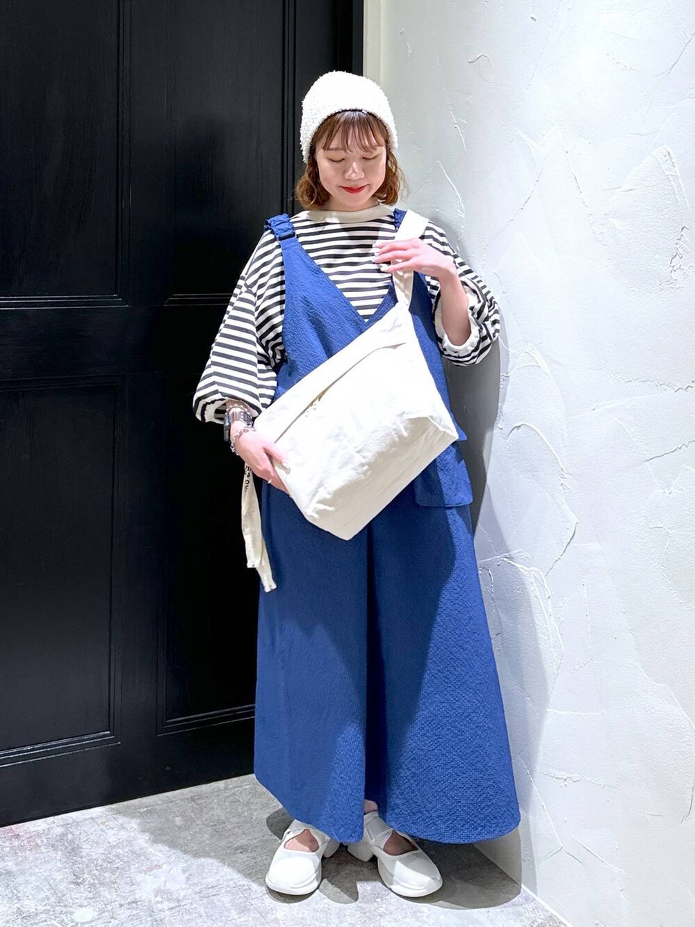 ブルー系のジャンパースカート、ベージュ系のスニーカー、ブラウン系のショルダーバッグを着用したレディースの夏コーディネートの6枚目の写真