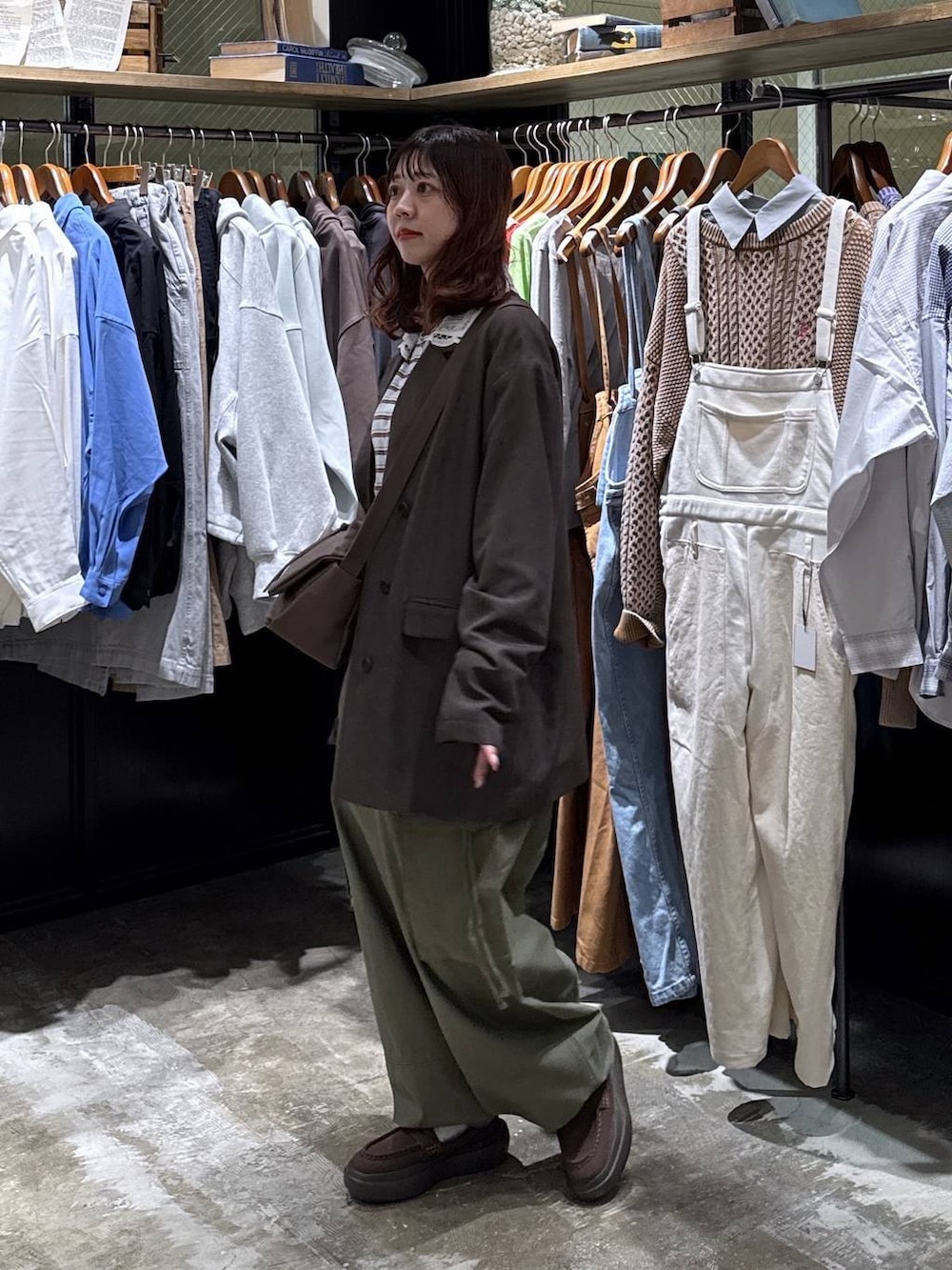 ブラウン系のショルダーバッグ、グリーン系のカーゴパンツ、ブルー系のTシャツ/カットソーを着用したレディースの冬コーディネートの7枚目の写真