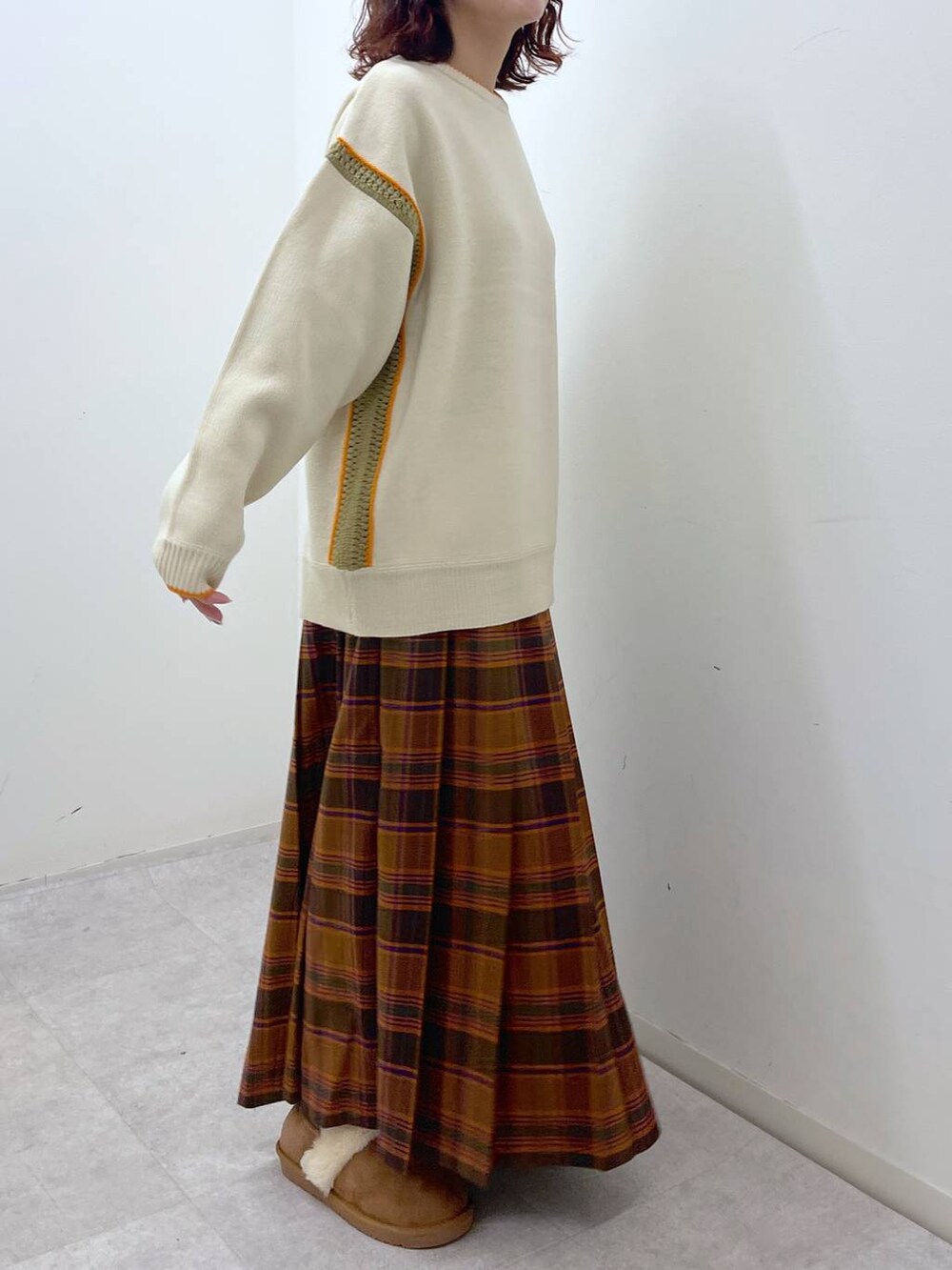 オレンジ系のスカート、ベージュ系のニット/セーター、イエロー系のその他シューズを着用したレディースの冬コーディネートの5枚目の写真