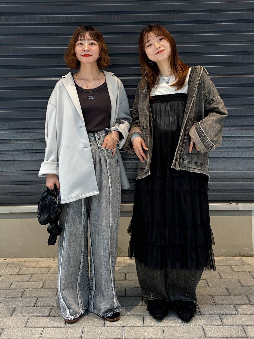 グレー系のTシャツ/カットソー、ブラック系のスカート、グレー系のデニムパンツを着用したレディースの秋コーディネートの9枚目の写真