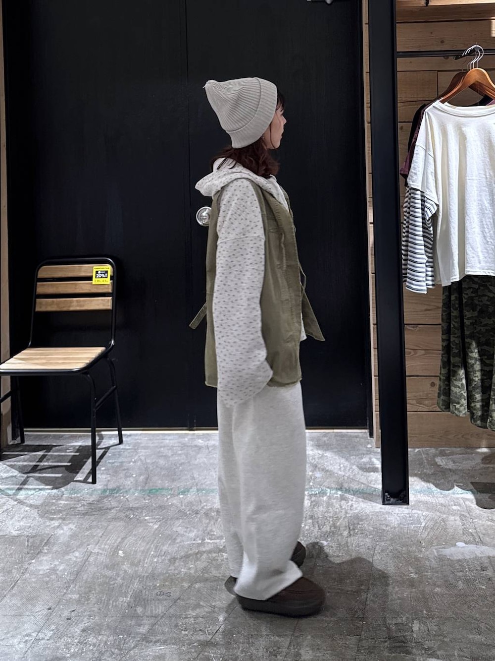 グリーン系のベスト、ベージュ系のパーカー、ブラウン系のローファーを着用したレディースの冬コーディネートの5枚目の写真