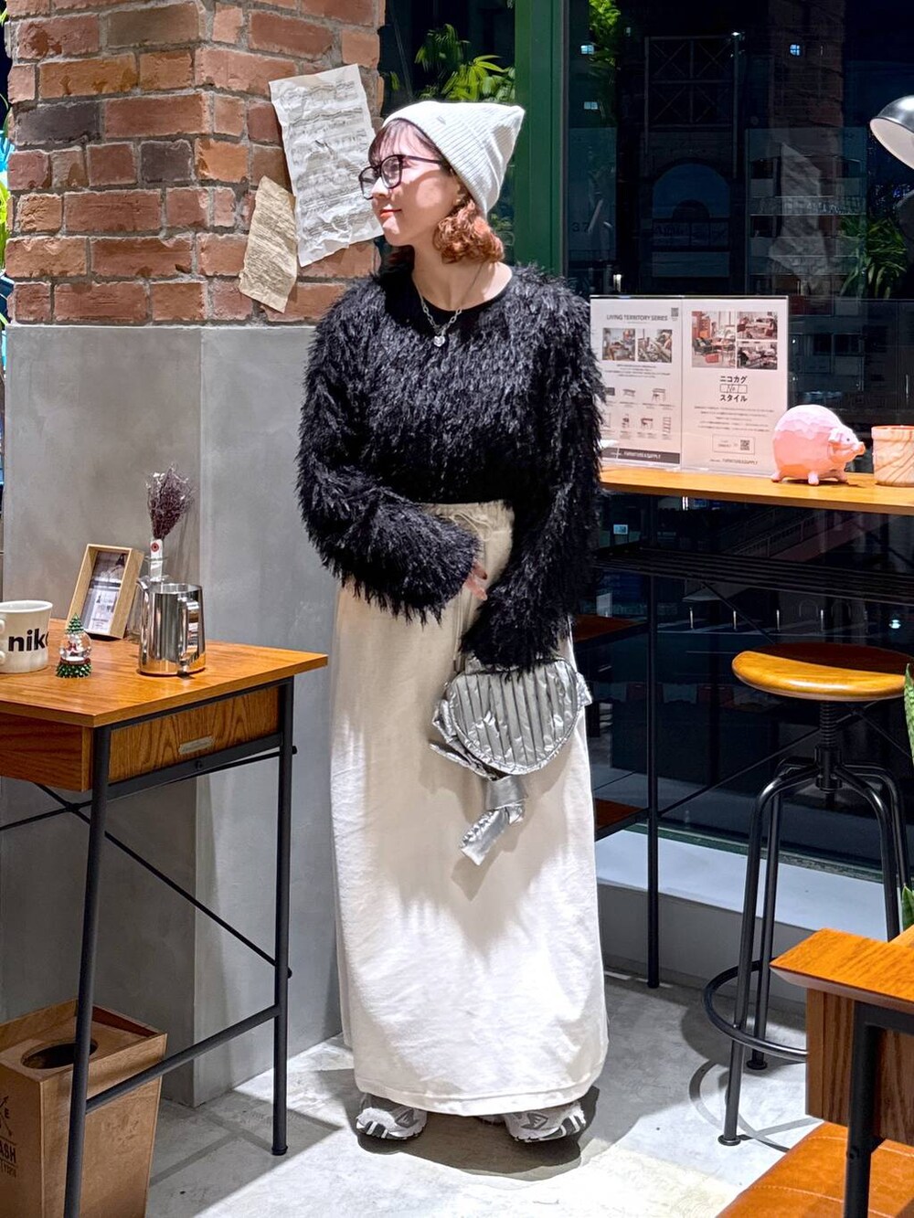 シルバー系のショルダーバッグ、ブラック系のその他トップス、ベージュ系のスカートを着用したレディースの冬コーディネートの9枚目の写真