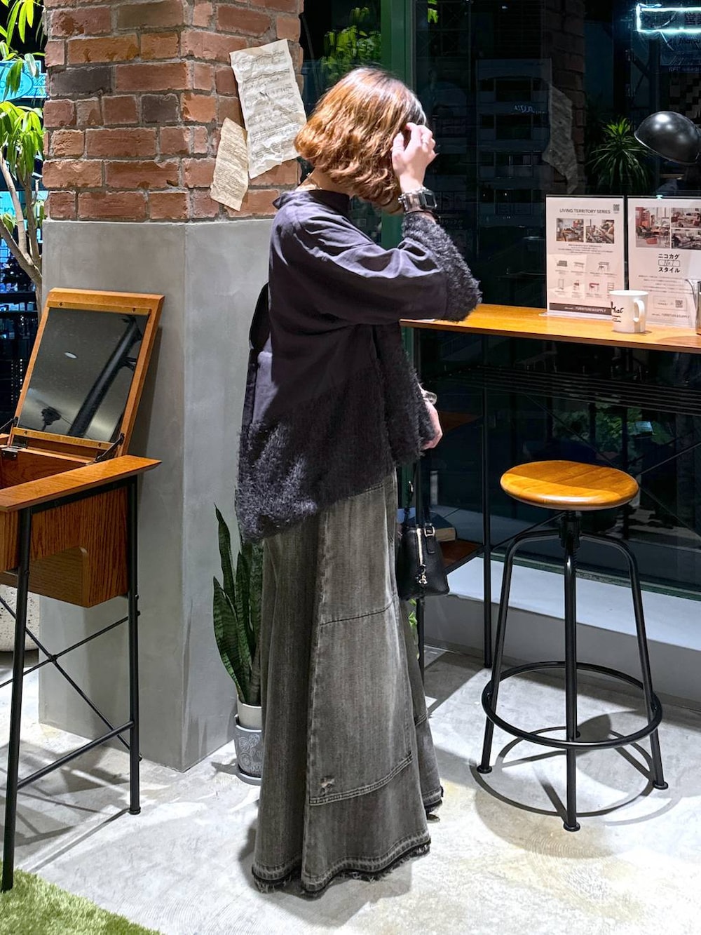 ブラック系のバレエシューズ、ブラック系のショルダーバッグ、ブラウン系のデニムパンツを着用したレディースの秋コーディネートの2枚目の写真