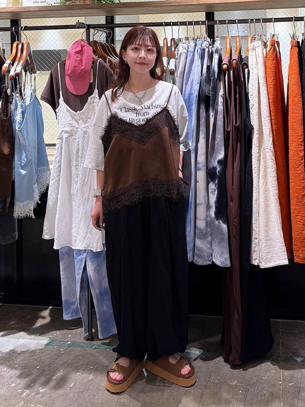 ブラウン系のサンダル、ブラック系のその他パンツ、ベージュ系のTシャツ/カットソーを着用したレディースの夏コーディネートの2枚目の写真