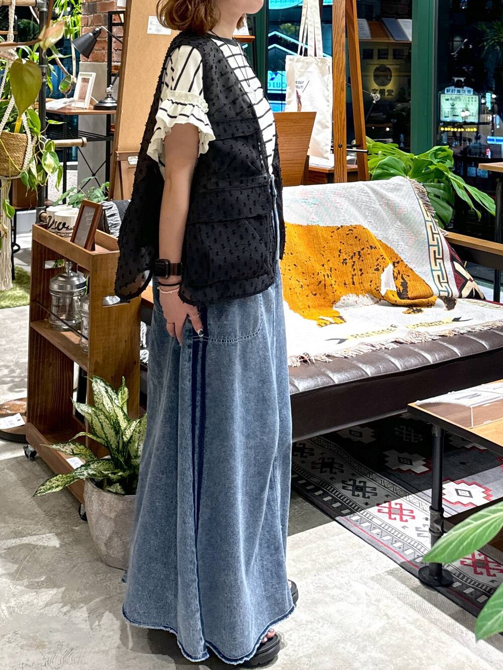 ブラック系のサンダル、ブラック系のベスト、ブルー系のスカートを着用したレディースの夏コーディネートの7枚目の写真