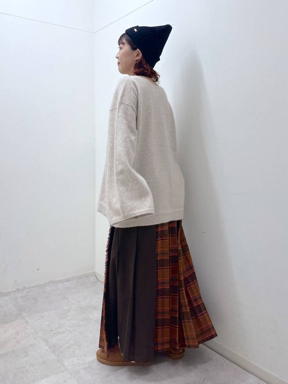 オレンジ系のスカート、ベージュ系のニット/セーター、イエロー系のその他シューズを着用したレディースの冬コーディネートの5枚目の写真