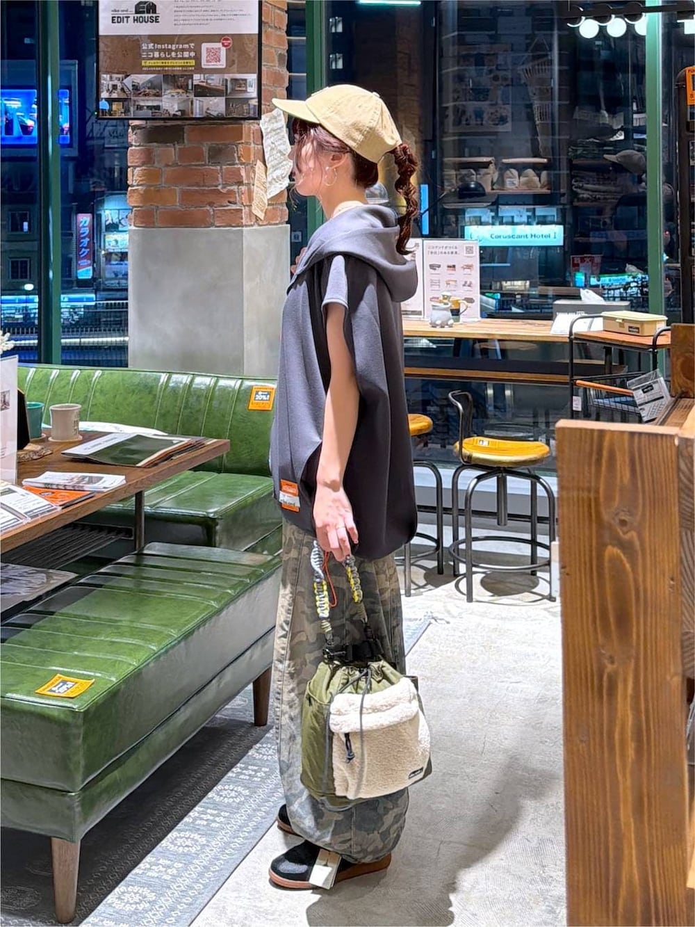 グレー系のベスト、グリーン系のデニムパンツ、グリーン系のショルダーバッグを着用したレディースの夏コーディネートの3枚目の写真