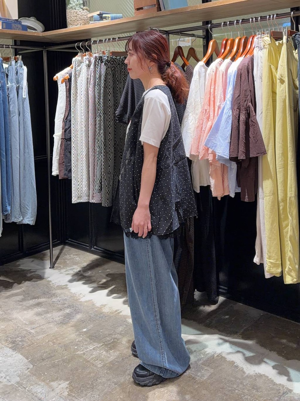 ブラック系のスニーカー、ブラック系のベスト、ホワイト系のTシャツ/カットソーを着用したレディースの夏コーディネートの3枚目の写真