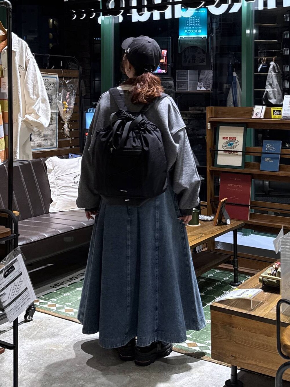 ブルー系のスカート、グレー系のTシャツ/カットソー、ブラック系のバックパック/リュックを着用したレディースの春コーディネートの4枚目の写真