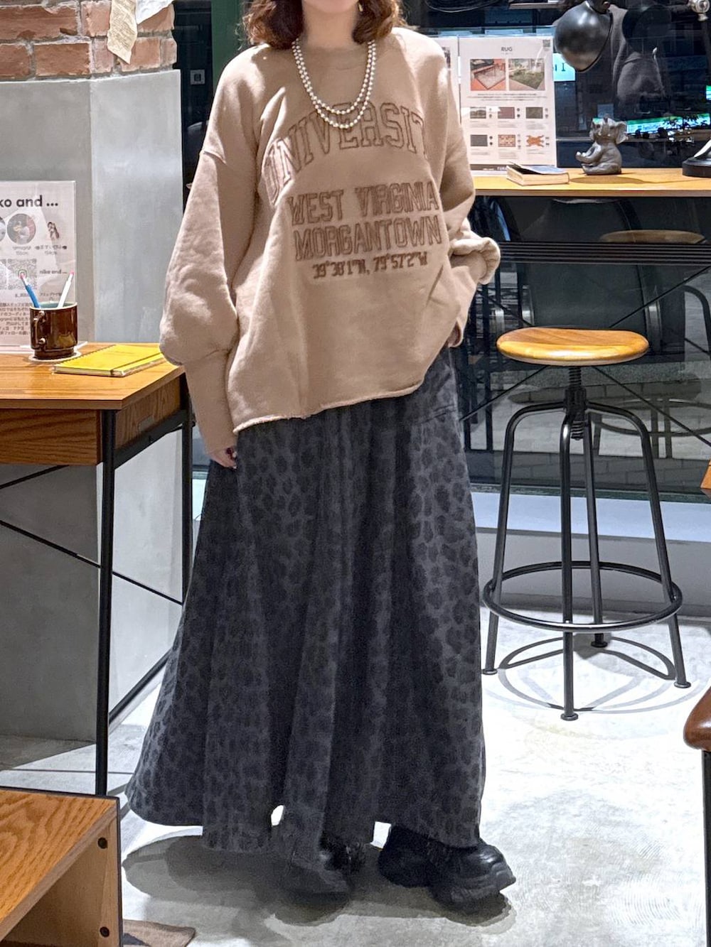 グレー系のスカート、イエロー系のスウェット、ブラック系のスニーカーを着用したレディースの秋コーディネートの5枚目の写真