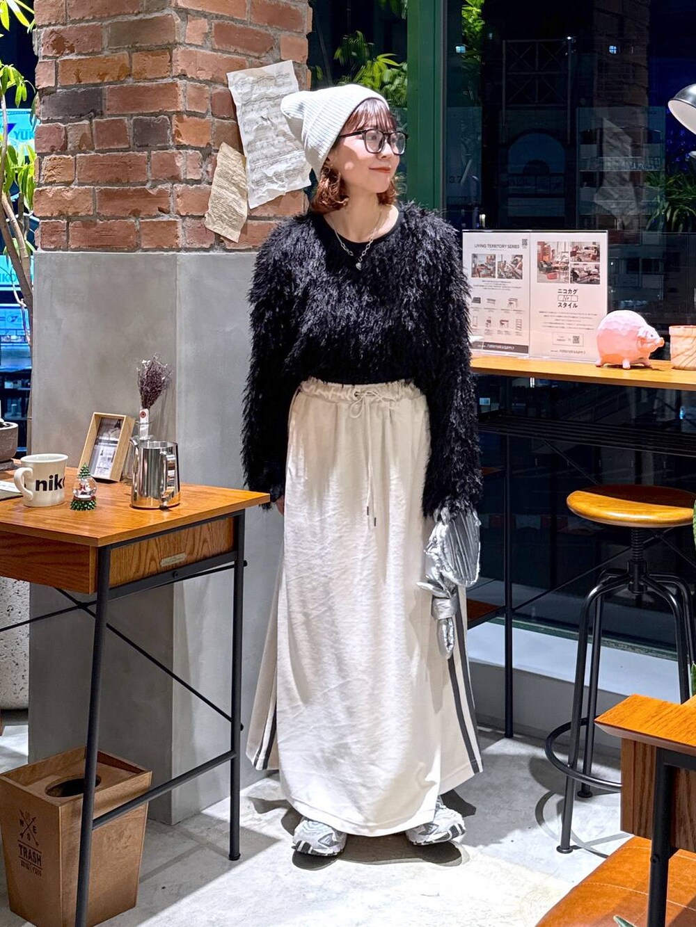 シルバー系のショルダーバッグ、ブラック系のその他トップス、ベージュ系のスカートを着用したレディースの冬コーディネートの7枚目の写真