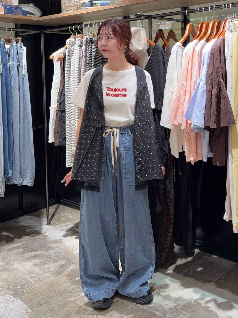 ブラック系のスニーカー、ブラック系のベスト、ホワイト系のTシャツ/カットソーを着用したレディースの夏コーディネートの2枚目の写真