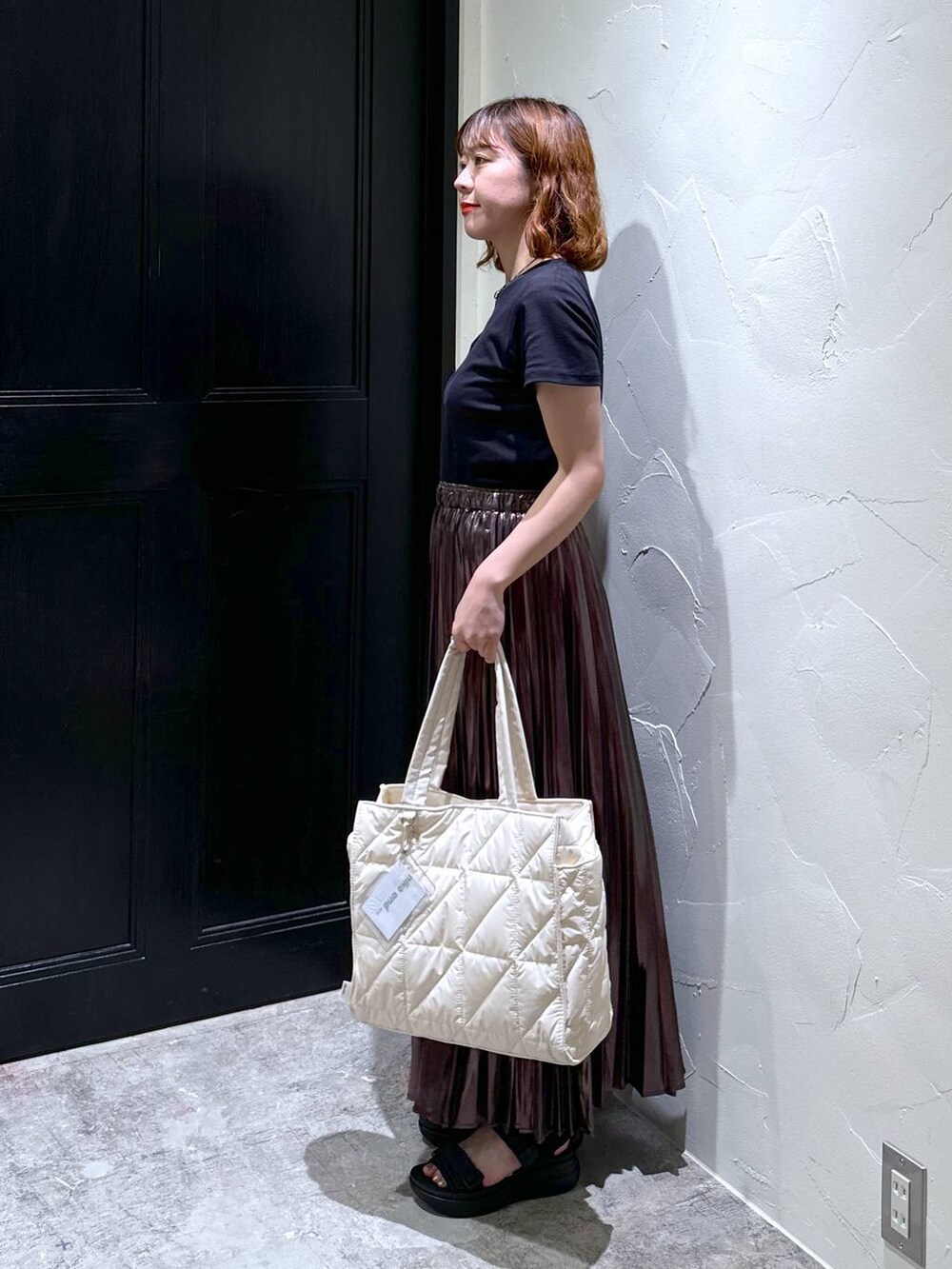 ブラック系のサンダル、ホワイト系のトートバッグ、ベージュ系のスカートを着用したレディースの夏コーディネートの2枚目の写真