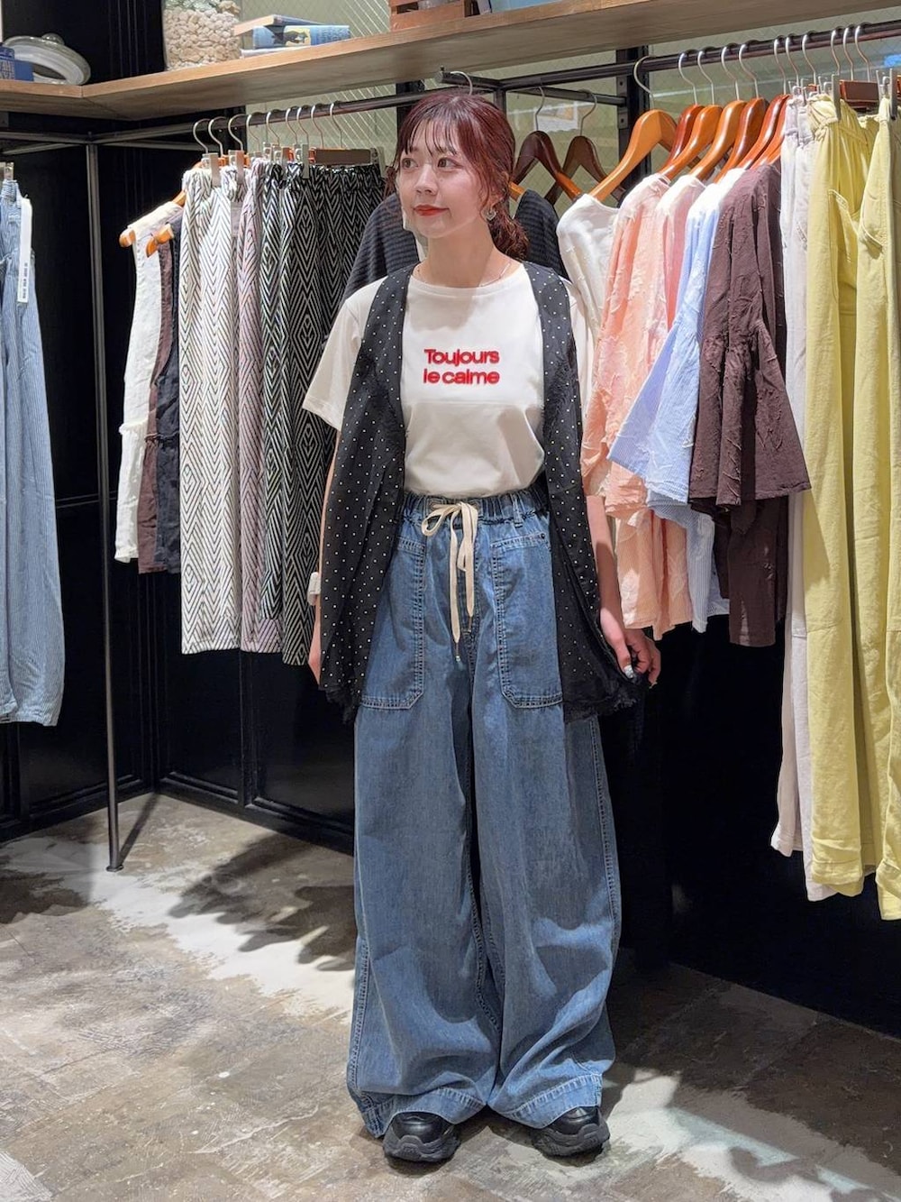ブラック系のスニーカー、ブラック系のベスト、ホワイト系のTシャツ/カットソーを着用したレディースの夏コーディネートの6枚目の写真
