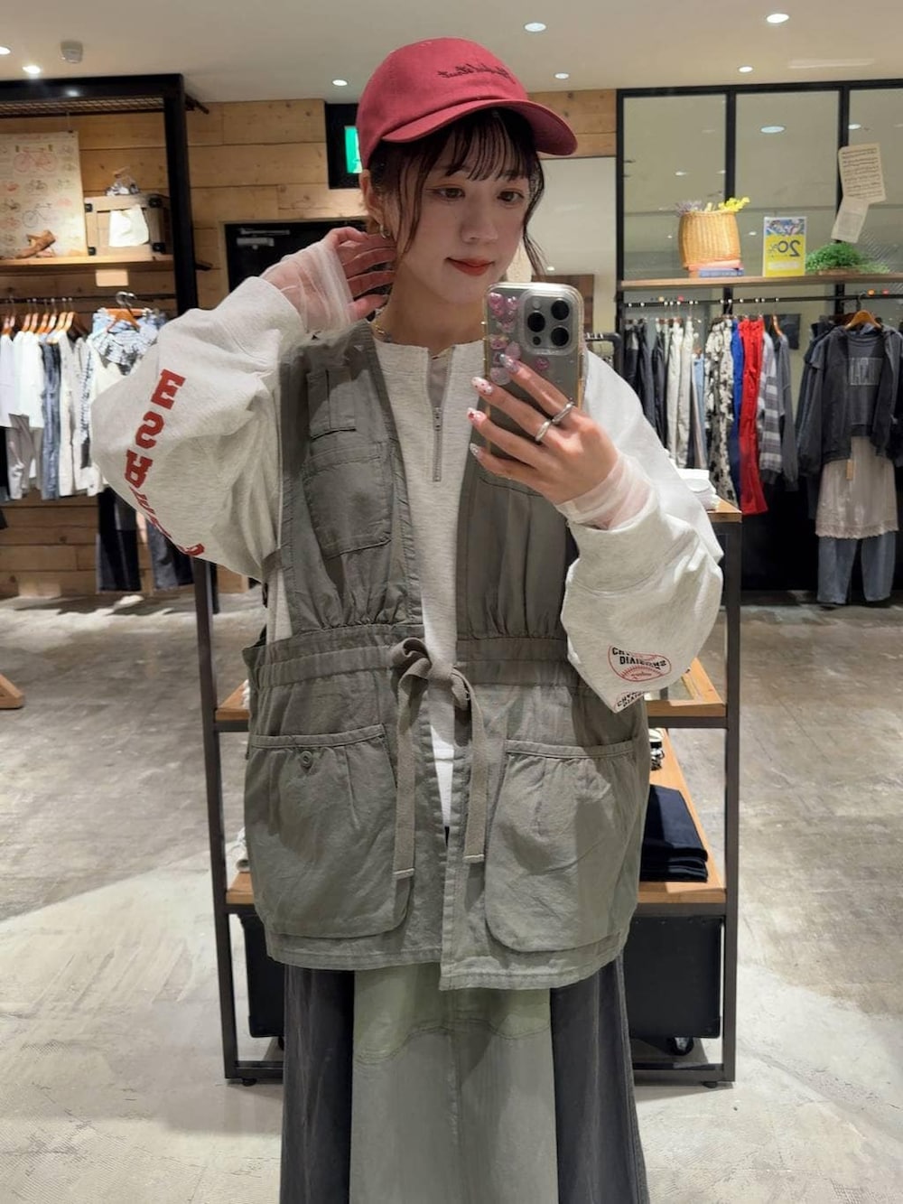 グリーン系のベスト、ホワイト系のTシャツ/カットソー、グレー系のスウェットを着用したレディースの春コーディネートの2枚目の写真