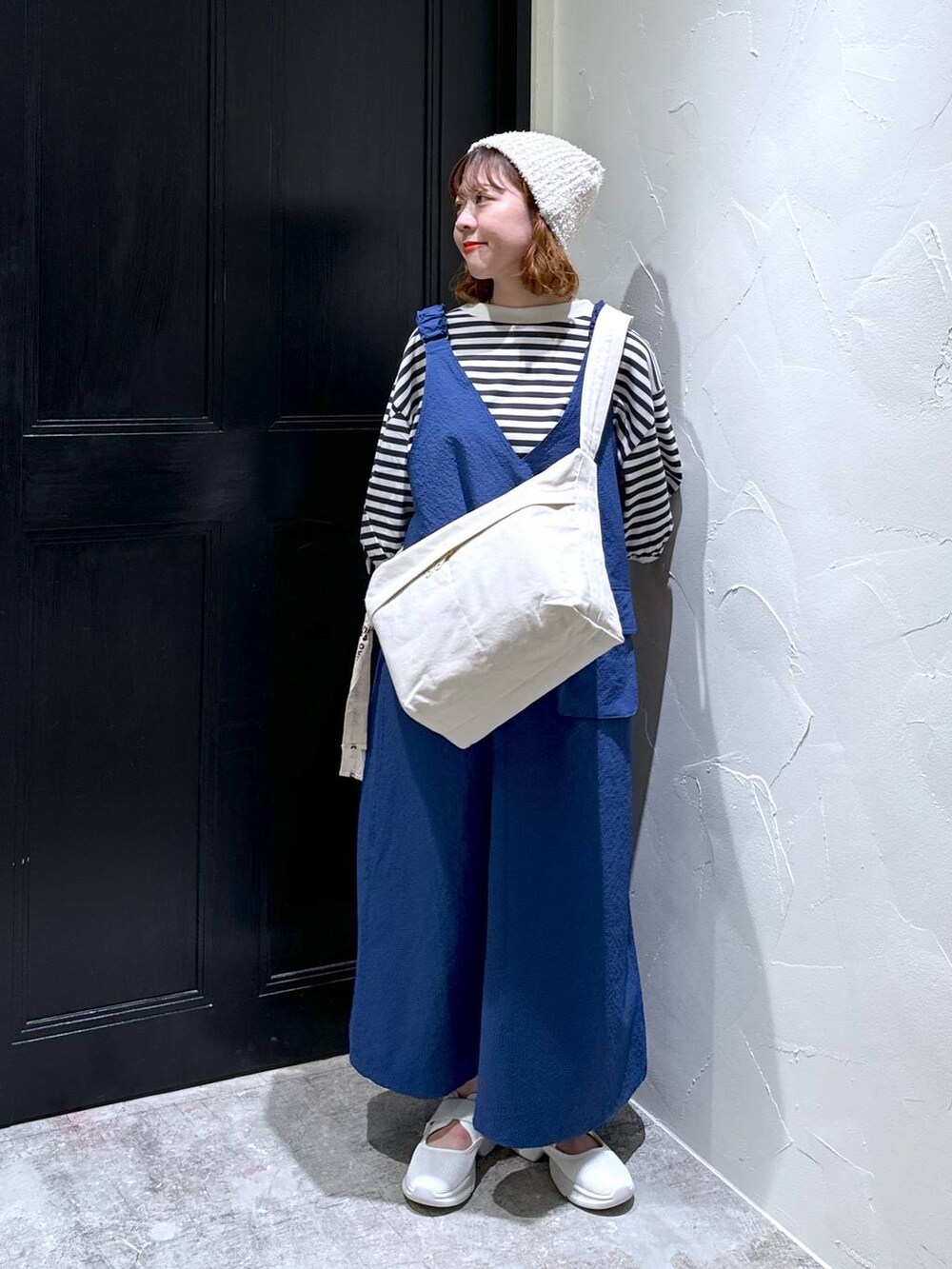 ブルー系のジャンパースカート、ベージュ系のスニーカー、ブラウン系のショルダーバッグを着用したレディースの夏コーディネートの7枚目の写真