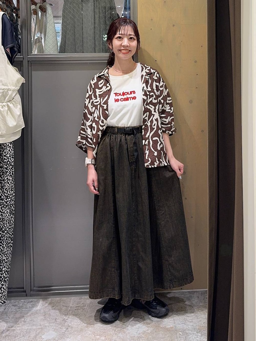 ブラウン系のスカート、ブラウン系のシャツ/ブラウス、ホワイト系のTシャツ/カットソーを着用したレディースの春コーディネートの5枚目の写真