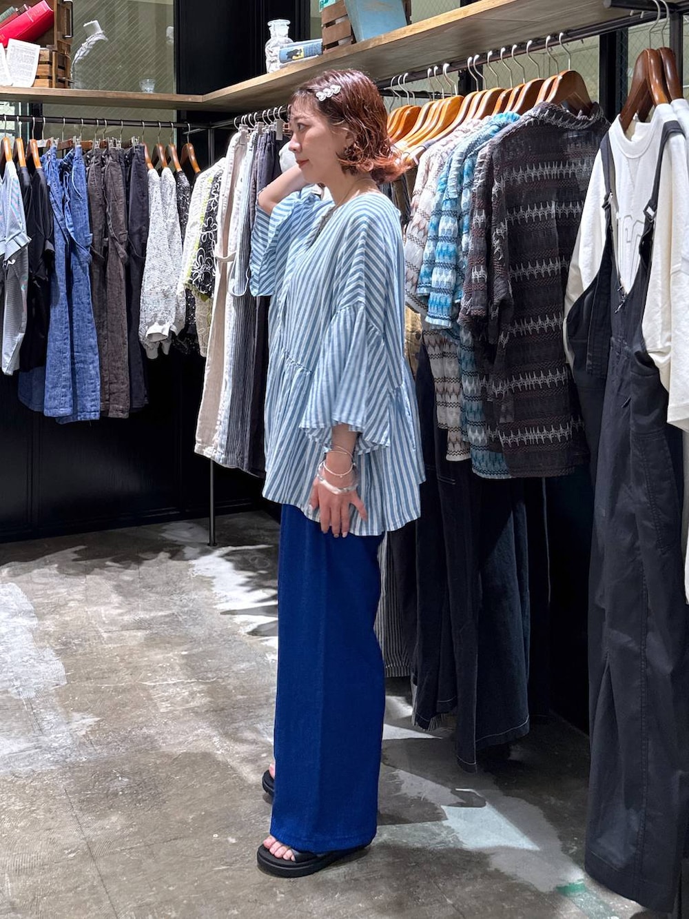 グレー系のタンクトップ、ブラック系のサンダル、ブルー系のその他パンツを着用したレディースの夏コーディネートの2枚目の写真