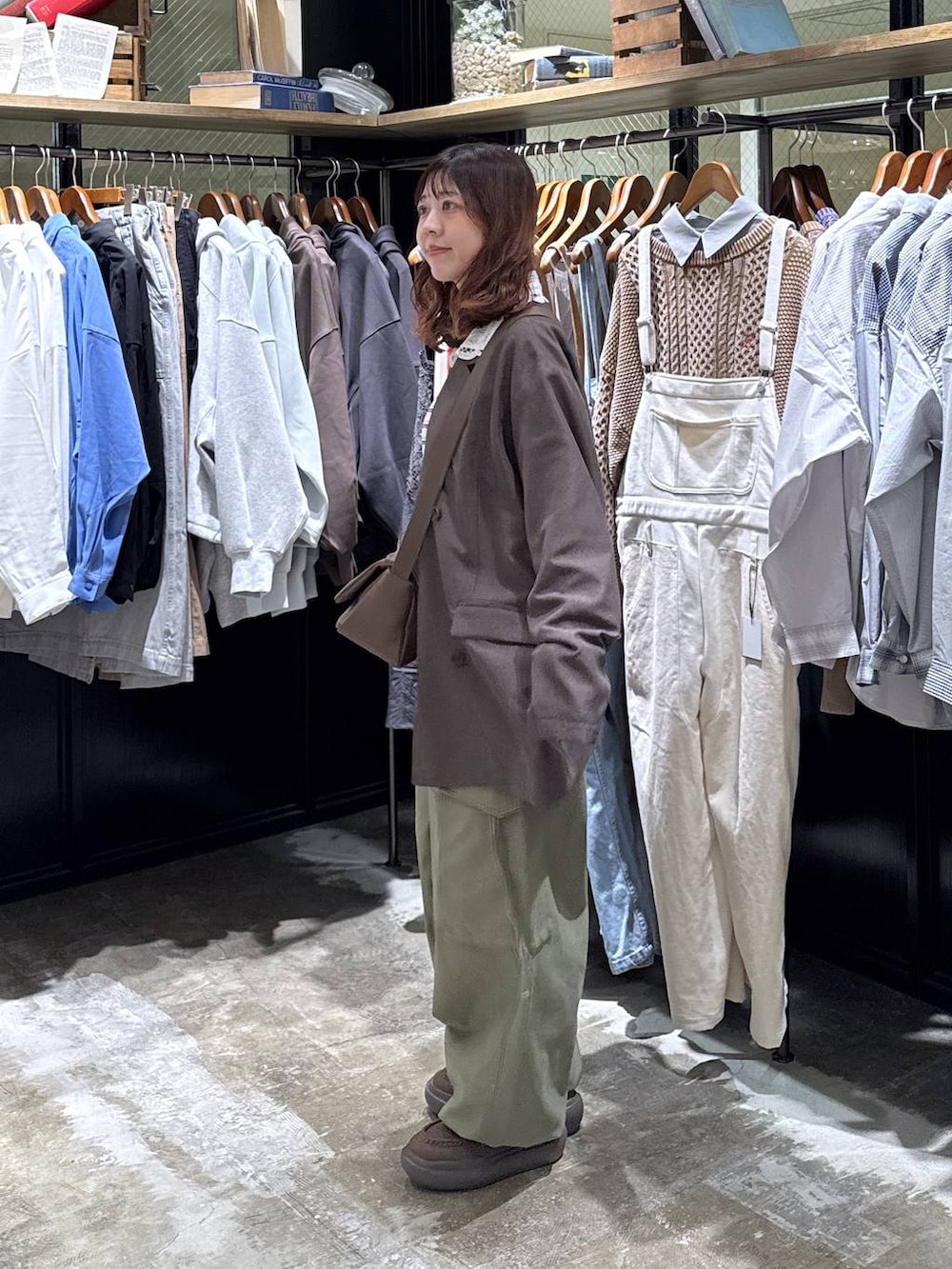 ブラウン系のショルダーバッグ、グリーン系のカーゴパンツ、ブルー系のTシャツ/カットソーを着用したレディースの冬コーディネートの3枚目の写真